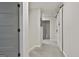 Well-lit hallway featuring neutral carpet, white walls, and multiple doorways at 205 Valley View Dr, Tyrone, GA 30290