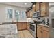 Well-lit kitchen featuring stainless steel appliances, granite countertops, and blonde wood flooring at 205 Valley View Dr, Tyrone, GA 30290