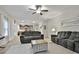 Living room with gray sofas, a ceiling fan, and an open view to the kitchen at 205 Valley View Dr, Tyrone, GA 30290