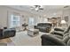 Living room with gray sofas, a ceiling fan, and an open view to the kitchen at 205 Valley View Dr, Tyrone, GA 30290