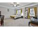 Spacious main bedroom featuring a ceiling fan, a sitting area, and two large windows at 205 Valley View Dr, Tyrone, GA 30290