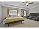 Spacious main bedroom featuring a ceiling fan, a sitting area, and two large windows at 205 Valley View Dr, Tyrone, GA 30290