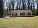 A ranch-style house with a covered porch area and a spacious front lawn surrounded by trees at 61 Scoby Ct, Jonesboro, GA 30238