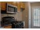 A view of the gas range and stainless microwave inside of this kitchen at 61 Scoby Ct, Jonesboro, GA 30238