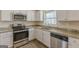 Updated kitchen featuring white cabinetry, stainless steel appliances, granite counters and hardwood floors at 3465 Tulip Dr, Decatur, GA 30032
