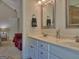 Bathroom featuring dual sinks, white cabinets, and a view into the bedroom and shower at 809 Mcbean Ct, Mcdonough, GA 30252