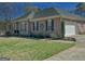 View of brick home with manicured lawn, black shutters, two-car garage, and mature landscaping at 809 Mcbean Ct, Mcdonough, GA 30252