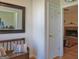 Hallway featuring hardwood floors, decorative mirror, bench and doorway to living area at 809 Mcbean Ct, Mcdonough, GA 30252