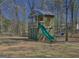 Backyard playhouse featuring two levels, a slide, climbing ladder and mature trees at 809 Mcbean Ct, Mcdonough, GA 30252