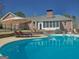 Gorgeous pool with chairs, umbrella and nice landscaping, surrounded by brick home at 809 Mcbean Ct, Mcdonough, GA 30252