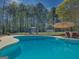 Stunning backyard pool featuring lounge chairs, swing, mature trees and privacy fence at 809 Mcbean Ct, Mcdonough, GA 30252