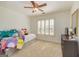 Well-lit bedroom with a ceiling fan, window with shutters, and colorful pillows on the bed at 265 Ridgewood Dr, Fayetteville, GA 30215