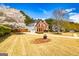 Serene property with well-maintained lawn featuring two-story red brick home and flowering trees at 265 Ridgewood Dr, Fayetteville, GA 30215