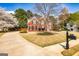 Classic two-story red brick home situated on a vast lawn and mature tree backdrop at 265 Ridgewood Dr, Fayetteville, GA 30215