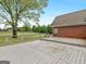 A wooden deck overlooks a large grassy lawn with mature trees and a brick house at 142 Gillson Dr, Mcdonough, GA 30253