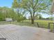 A wooden deck overlooking a sprawling green lawn with mature trees and distant house at 142 Gillson Dr, Mcdonough, GA 30253