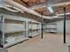 Unfinished basement features exposed pipes and concrete walls with rows of empty metal shelving at 142 Gillson Dr, Mcdonough, GA 30253