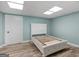 Basement bedroom features a light blue painted wall, modern vinyl flooring, and natural lighting at 142 Gillson Dr, Mcdonough, GA 30253