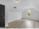 Bright bedroom featuring light-colored wood floors, a window, and a modern light fixture at 142 Gillson Dr, Mcdonough, GA 30253