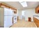 Kitchen features white appliances, stone-look counters, wood cabinets, and vinyl flooring at 6316 Rockland Rd, Lithonia, GA 30038