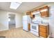 Kitchen features white appliances, stone-look counters, wood cabinets, and vinyl flooring at 6316 Rockland Rd, Lithonia, GA 30038