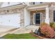 Charming front exterior featuring a two car garage, black door, and manicured landscaping at 4365 Sunflower Cir, Cumming, GA 30040
