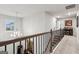 Well-lit upstairs hallway with neutral carpet, decorative chandelier, and a wooden railing leading to stairs at 4365 Sunflower Cir, Cumming, GA 30040