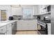 Modern kitchen with white cabinets, stainless steel appliances, gray backsplash, and tile floors at 109 Bowen Cir, Atlanta, GA 30313