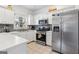 Modern kitchen with white cabinets, stainless steel appliances, gray backsplash, and tile floors at 109 Bowen Cir, Atlanta, GA 30313