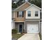 Charming two-story townhome featuring a brick facade, blue door, and attached one-car garage at 8642 Lakeview Commons # 36, Jonesboro, GA 30238