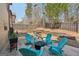 Cozy backyard features a patio with teal Adirondack chairs, a fire pit, and a grill, perfect for outdoor entertaining at 605 Camano Way, Mcdonough, GA 30253