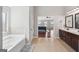 En-suite bathroom features double sink vanity, a soaking tub, and tiled floors at 605 Camano Way, Mcdonough, GA 30253