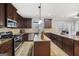 Spacious kitchen featuring dark wood cabinets, granite countertops, and stainless steel appliances at 605 Camano Way, Mcdonough, GA 30253