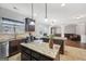 Open concept kitchen features granite countertops, dark wood cabinets and an island with pendant lighting at 605 Camano Way, Mcdonough, GA 30253