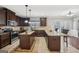 Spacious kitchen features dark wood cabinets, granite countertops, and stainless steel appliances at 605 Camano Way, Mcdonough, GA 30253