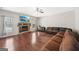 Living room with hardwood floors, a stone fireplace, a ceiling fan, and a comfortable leather sofa at 605 Camano Way, Mcdonough, GA 30253