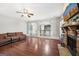 Open concept living room featuring hardwood floors, a fireplace, a ceiling fan, and access to other rooms at 605 Camano Way, Mcdonough, GA 30253