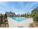 Community pool area featuring a pool house, a large pool, and well-maintained landscaping on a sunny day at 605 Camano Way, Mcdonough, GA 30253