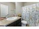 Well-lit bathroom features a vanity with granite countertop, commode, and a shower with a stylish curtain at 2458 Walker Dr, Hampton, GA 30228