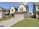 Charming two-story home showcasing a brick and siding exterior with an attached two-car garage at 2458 Walker Dr, Hampton, GA 30228