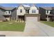 Two-story home featuring a brick and siding facade, two car garage and well manicured front lawn at 2458 Walker Dr, Hampton, GA 30228