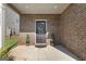 Inviting front porch featuring a brick facade, decorative door, and manicured shrubbery at 2458 Walker Dr, Hampton, GA 30228