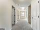 Bright hallway with neutral tones, plush carpet and white doors leading to various rooms in the house at 2458 Walker Dr, Hampton, GA 30228