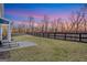 Spacious backyard featuring a well-maintained lawn, a patio, and a black fence bordering a wooded area at 8110 Brewton Bnd, Cumming, GA 30028