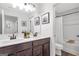 Bright bathroom features double sinks with dark wood cabinets, a large mirror, and a shower with a tub at 8110 Brewton Bnd, Cumming, GA 30028