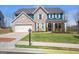 Charming two-story home featuring brick accents, white trim, a well-kept lawn, and a two car garage at 8110 Brewton Bnd, Cumming, GA 30028