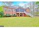 Expansive lawn, a covered porch, and brick architecture define the exterior of this home at 165 Hideaway Dr, Fayetteville, GA 30215