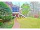 A brick home featuring a screened porch, a staircase leading to the yard, and lush green grass at 165 Hideaway Dr, Fayetteville, GA 30215
