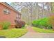 Brick home featuring a brick walkway, lush green landscaping, and mature trees in backyard at 165 Hideaway Dr, Fayetteville, GA 30215