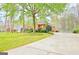 This well-maintained brick home features a long driveway, mature trees, and a beautifully landscaped front yard at 165 Hideaway Dr, Fayetteville, GA 30215